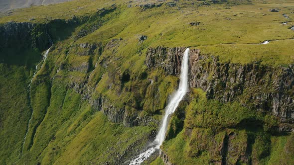 Aerial Drone Footage of Bjarnarfoss Waterfall with Its Green Cliffs in Western Iceland