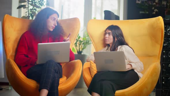 Diverse Multiethnic Couple Sitting on Couch Sofa in Stylish Living Room and Choosing Items Buy