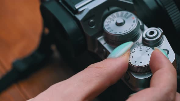 Woman's Hands Twist the Aperture Wheel on a Vintage Camera Closeup