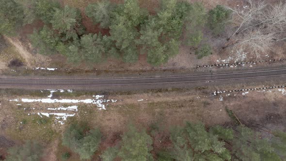 AERIAL: Railway in a Forest on a Gloomy Cloudy Day in Springtime