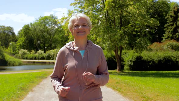 Senior Woman Running Along Summer Park