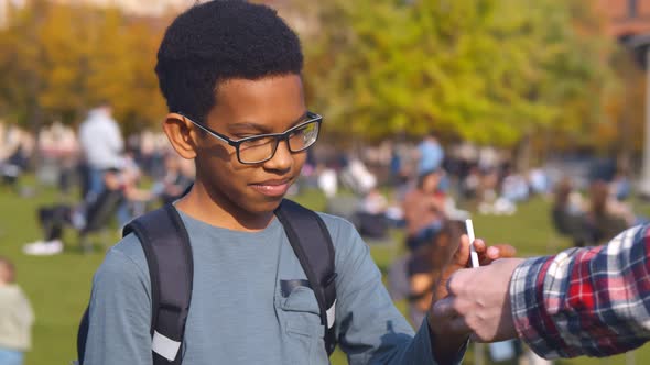 Portrait of African Preteen Boy Taking Cigarette From Dealer and Smoking