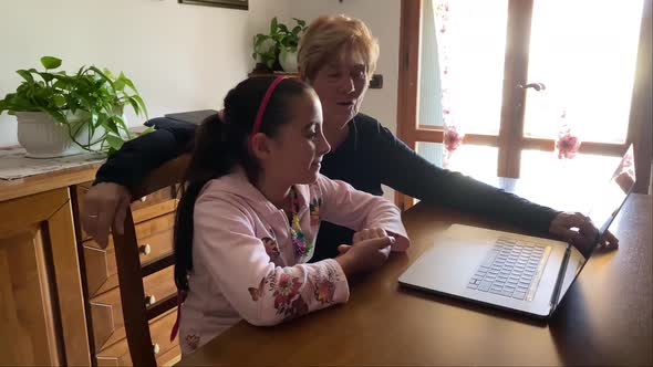 Young Girl with Her Grandma on a Videocall with Their Parents