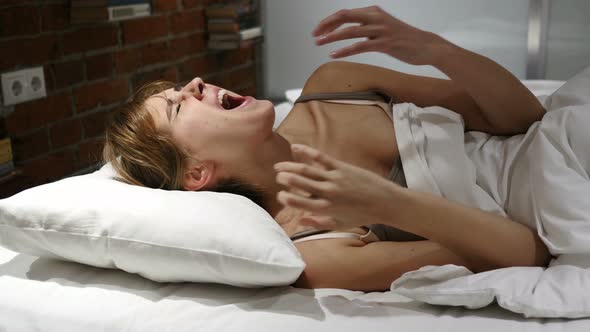 Frustrated Tense Woman Lying in Bed Screaming in Anger