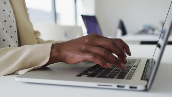 Close up of hands of african american businesswoman typing on laptop