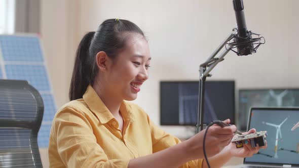 Close Up Of Asian Woman With Wind Turbine Fix The Circuit Board While Working With Laptop