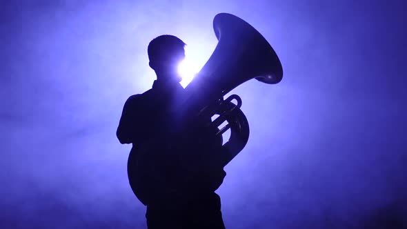 Musician in Silhouette Playing in Tuba, Smoky Studio. Slow Motion