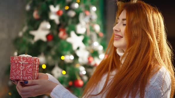 Beautiful Happy Red-haired Woman Sitting Background Christmas Tree and Smiling