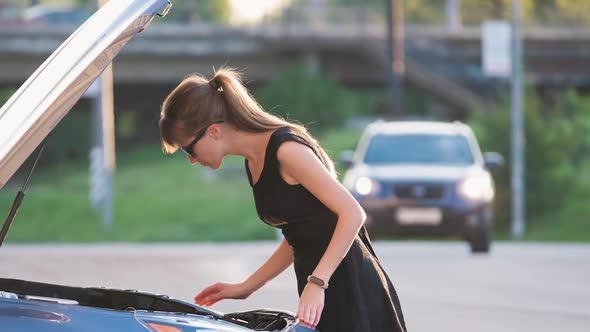 Helpless Woman Standing Near Her Car with Open Bonnet Inspecting Broken Motor