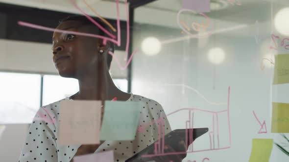 African american businesswoman inventing concept, making notes and smiling