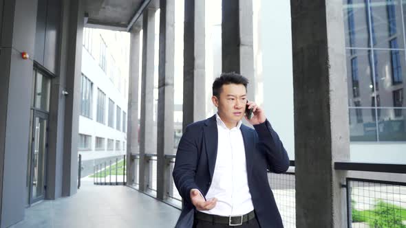 asian male businessman angry talking on the phone 
