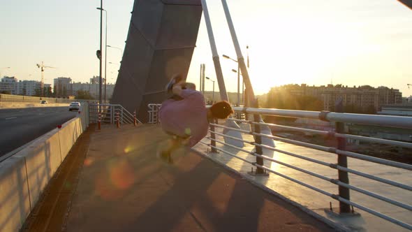 Summer Jogging of an Athlete with a Somersault Around Him in the Light of the Sun