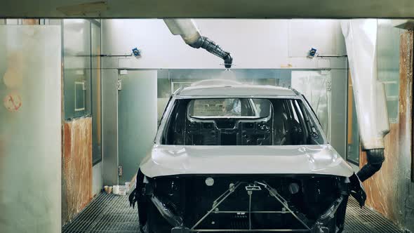 Robotic Arms Spray Painting a Vehicle Body at a Car Factory