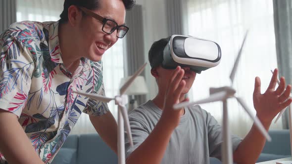 Asian Teacher Teaching Boy While Wearing Vr Glasses With Wind Turbine Model