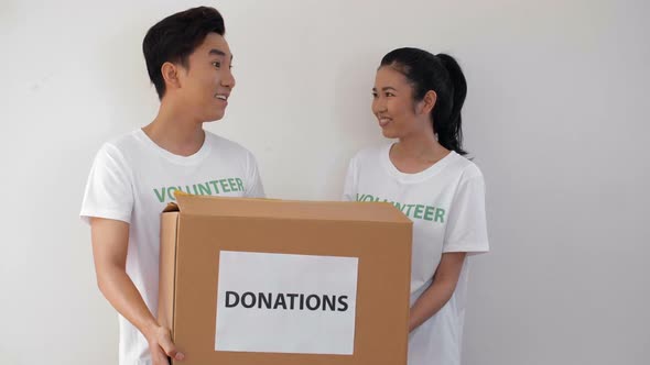Three Asian Volunteers with Donation Boxes