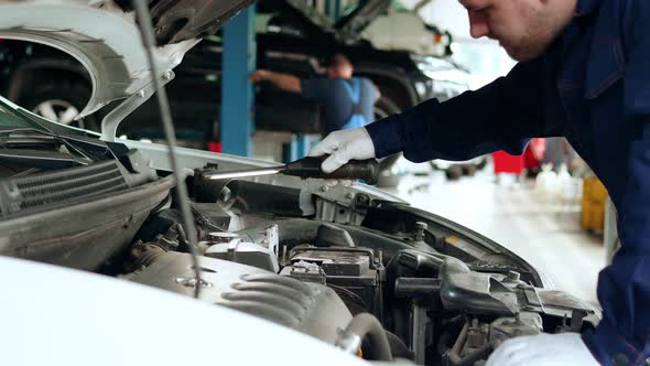 The Mechanic Conducts a Visual Inspection of the Car Engine