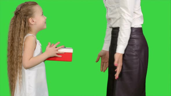 Young Charming Mother and Her Cute Daughter Opened Christmas Gifts on a Green Screen, Chroma Key
