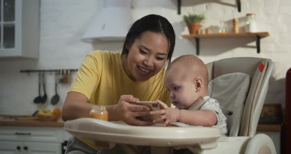 Mother Showing Smartphone To Baby