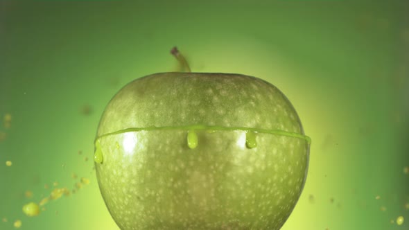 Half Green Apple Falling and Splashing on Green Background