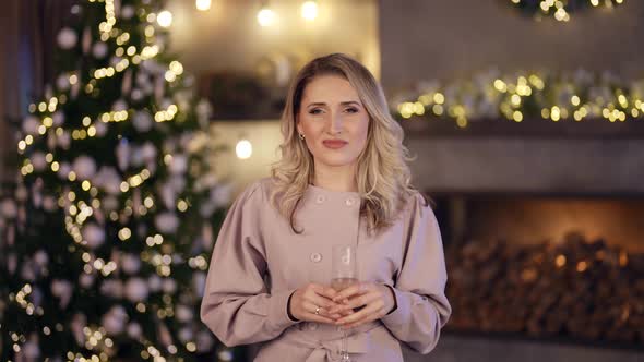 Beautiful Blonde Woman is Congratulating with Christmas and New Year From Cozy Apartment