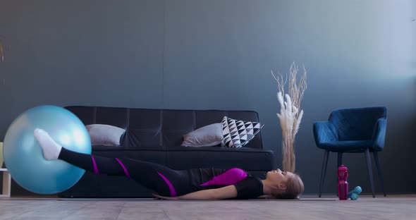 Young Sporty Woman Doing Exercise with Fitball