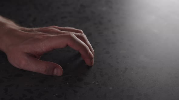 Slow Motion Young Man Hand Finger Tap on Terrazzo Countertop with Dim Light