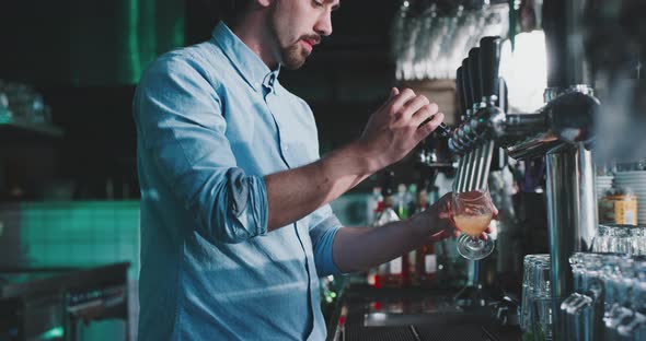 Barman crafting a beer in a urban modern bar