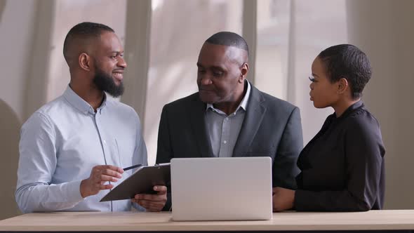 Mature 50s African Business Man Listens Advice of Afro Woman and Young Black Ethnic Guy Manager Team