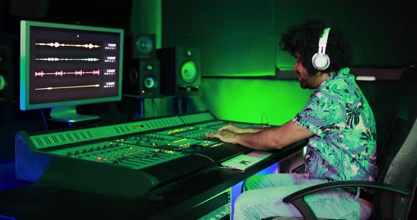 Musician and sound male engineer mixing new album inside boutique recording studio