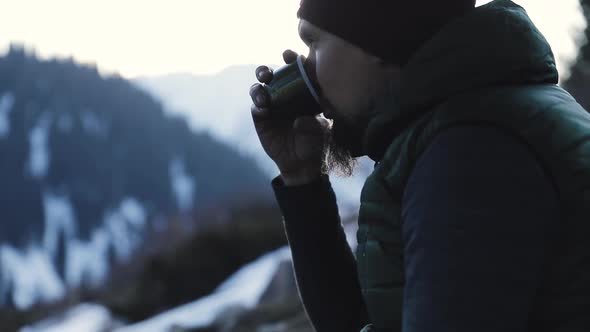 Bearded Man Drink Coffee in Winter Mountains