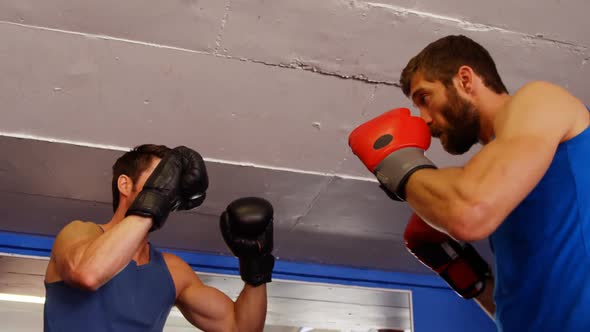 Man practising boxing with trainer