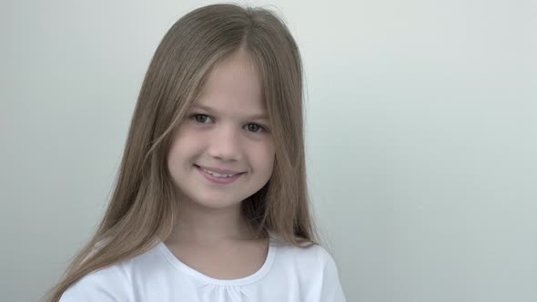 Portrait of Little Caucasian Girl in White Tshort Smiling Child on Gray Background Looking at Camera