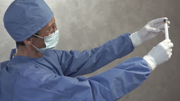 A doctor holds a test tube with a covid-19 test vaccine in his hand.