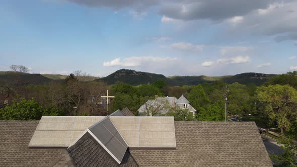 Flyover of residential neighborhood starting at a church facing toward the mountains with shadows.