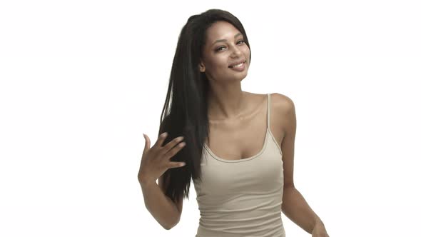 Attractive Modern Africanamerican Woman in Beige Tanktop Whip Hair and Touching It Advertising