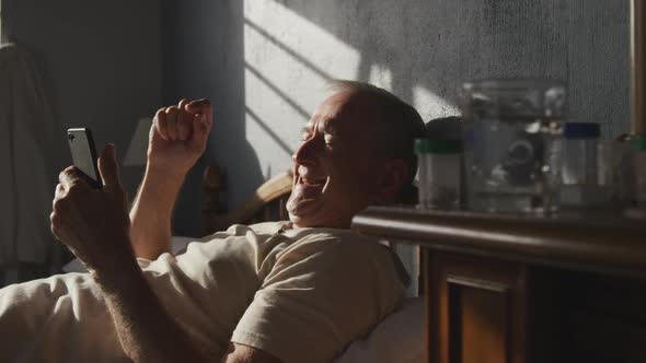 Senior man using digital tablet on bed