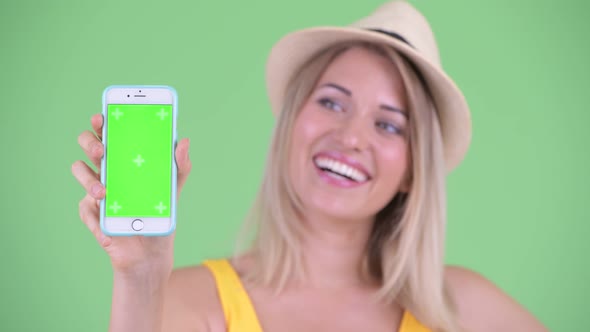 Face of Happy Young Blonde Tourist Woman Showing Phone