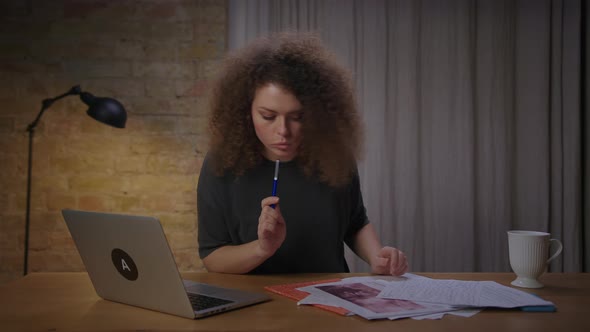 Young Female Inspecting Medical Tests Results Sitting at Home