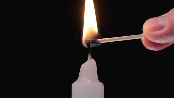 Single Candle Flame Lights at Black Background