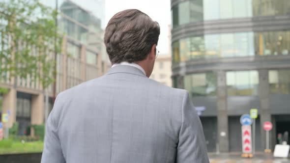 Back View of Walking Middle Aged Businessman