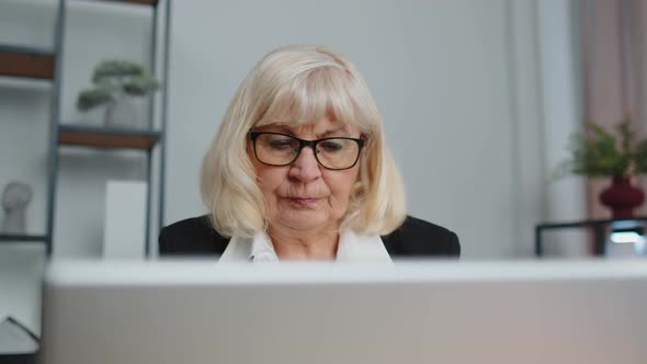 Senior Business Woman Freelancer Using Laptop Computer Sits at Workplace Typing Browsing at Office