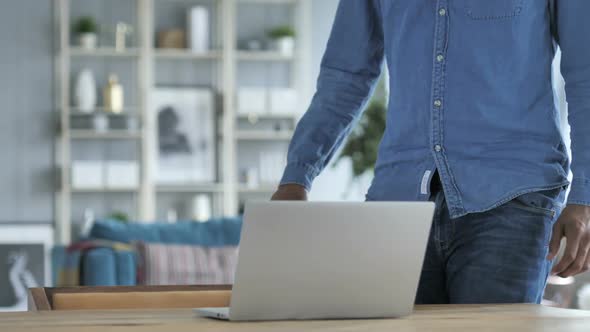 Young African Man Coming to Work on Laptop