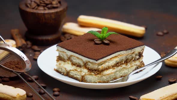 Portion of Traditional Italian Tiramisu dessert, savoiardi cookies and coffee beans