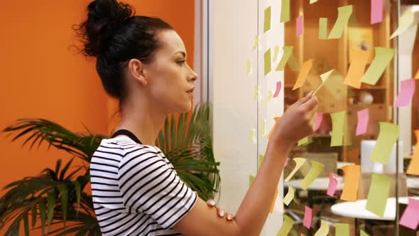 Female executive reading sticky notes