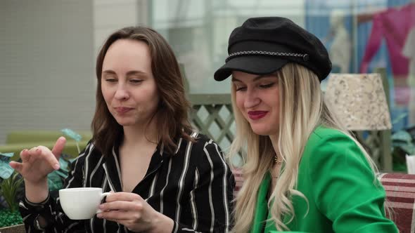 Two Female Friends Drink Tea in a Cafe