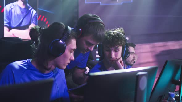 Gamers Discussing Strategy with Coach Before Match