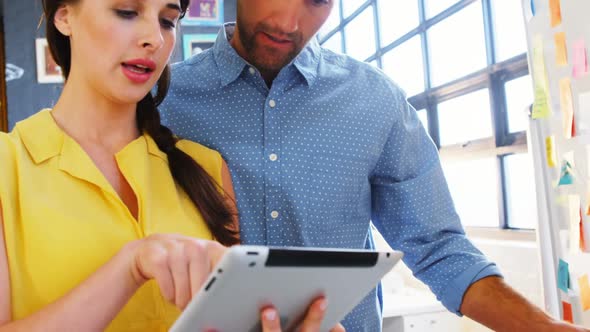 Business executives discussing over digital tablet