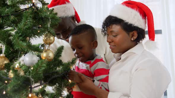 Happy Family Decorating Christmas Tree at Home