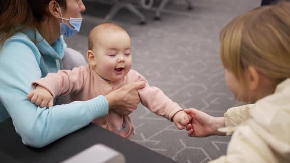 Happy Adorable Baby Girl Communication with Her Sister