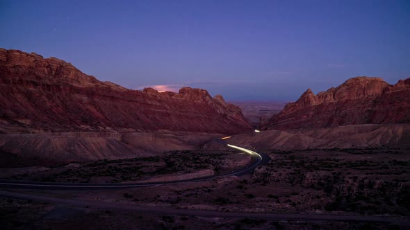 Day to night time lapse of traffic driving on winding road through Utah